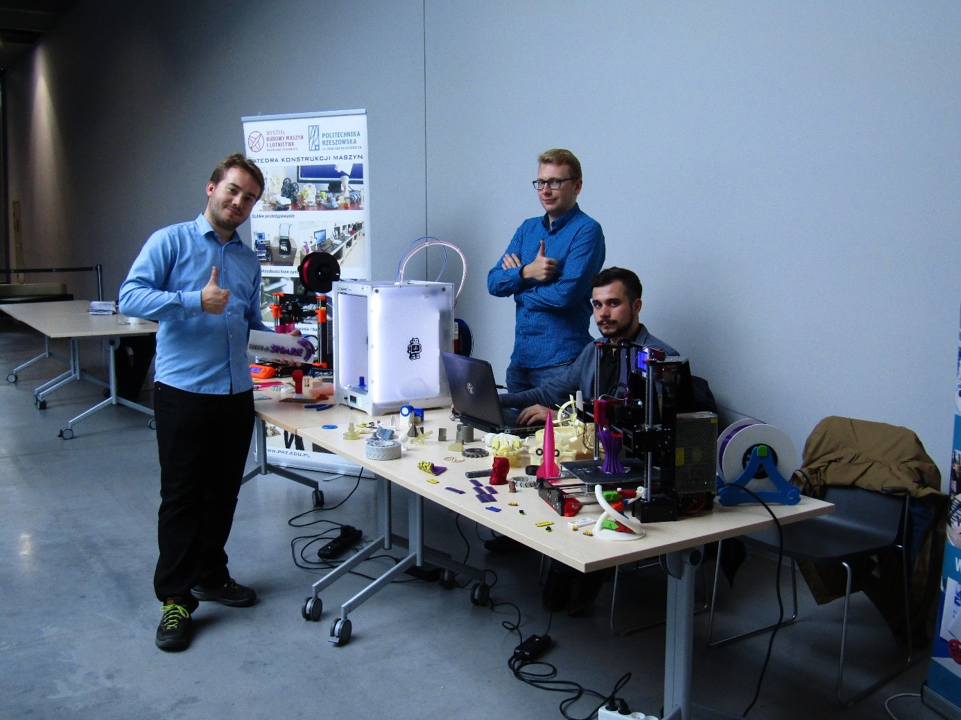Studenci prezentujący wydrukowane elementy oraz drukarki 3D podczas wydarzeń promnocyjnych PRz